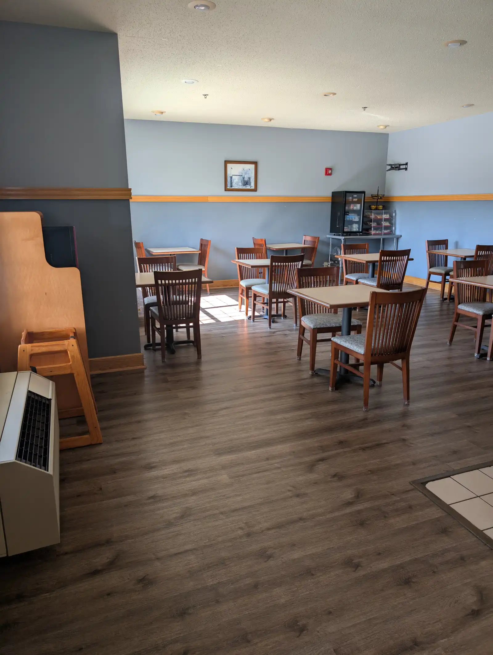 The breakfast dining room, with tables and chairs beside the windows