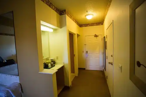 The entry of a guest room, with the coffee maker and vanity nook